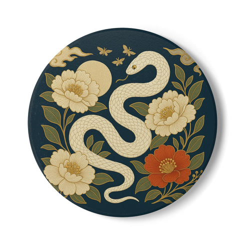 Round ceramic coaster with a chinoiserie-inspired design featuring a white snake among golden peonies, butterflies, and a glowing moon on a dark green background. Surrounded by floral and botanical accents with a soft vintage aesthetic. The coaster has a cork back and measures about 4 inches in diameter. Ideal for mugs, teacups, or wine glasses, this decorative piece suits witchy, victorian, and chinoiserie-inspired decor.
